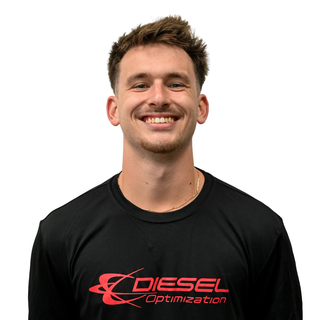 Young man with a mustache and goatee smiling, wearing a black shirt against a white background.