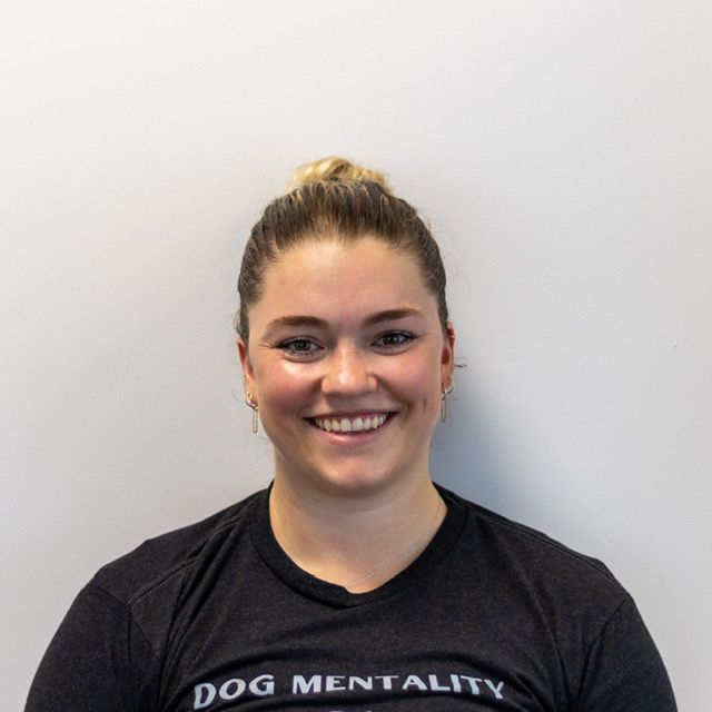 Woman with blonde hair up, wearing a black t-shirt with