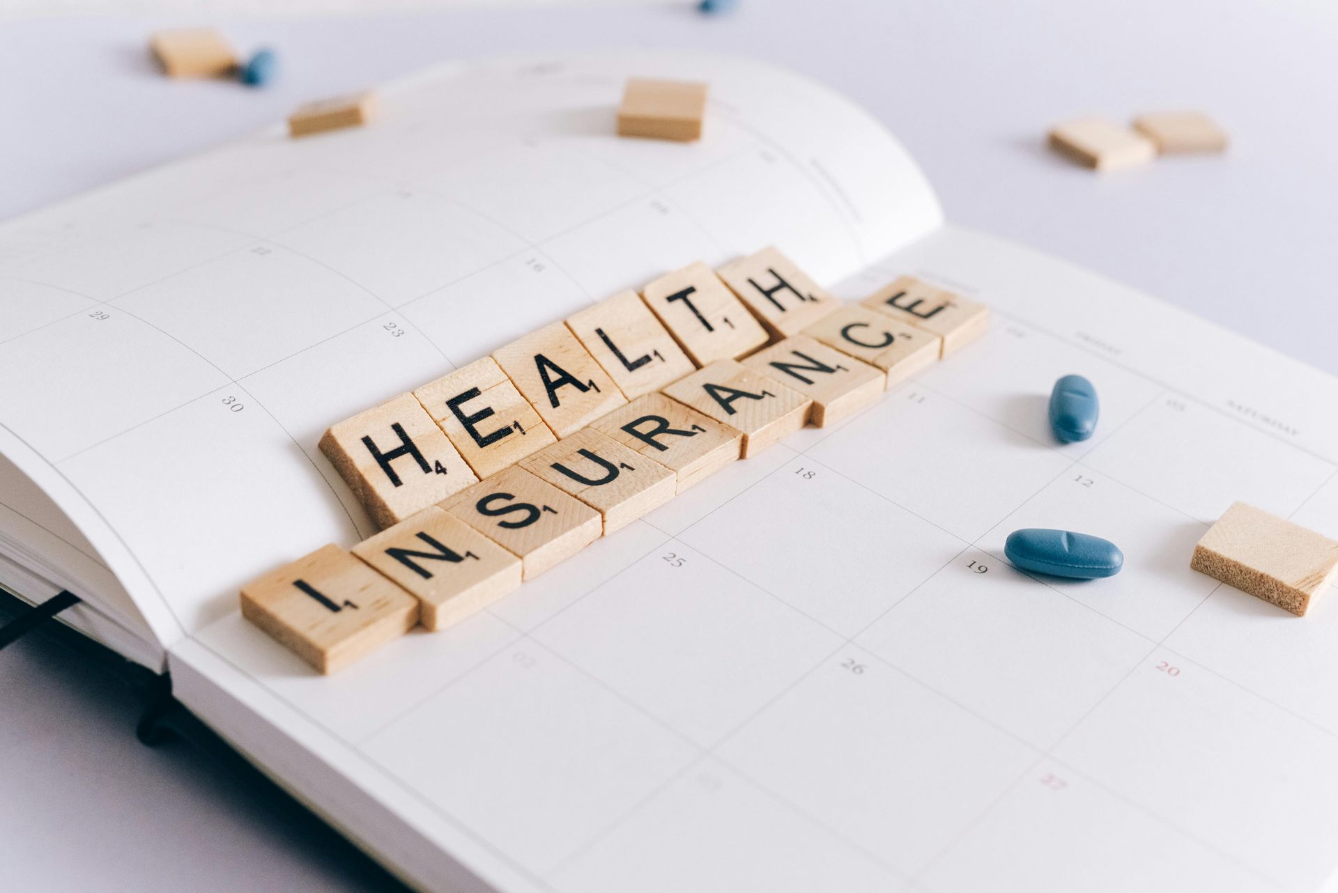 The word health insurance is written in wooden blocks on a calendar.