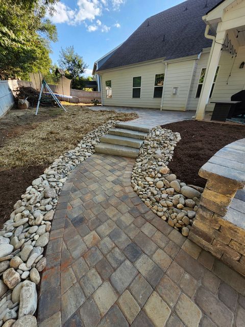 A sidewalk made of bricks is being built in a yard.
