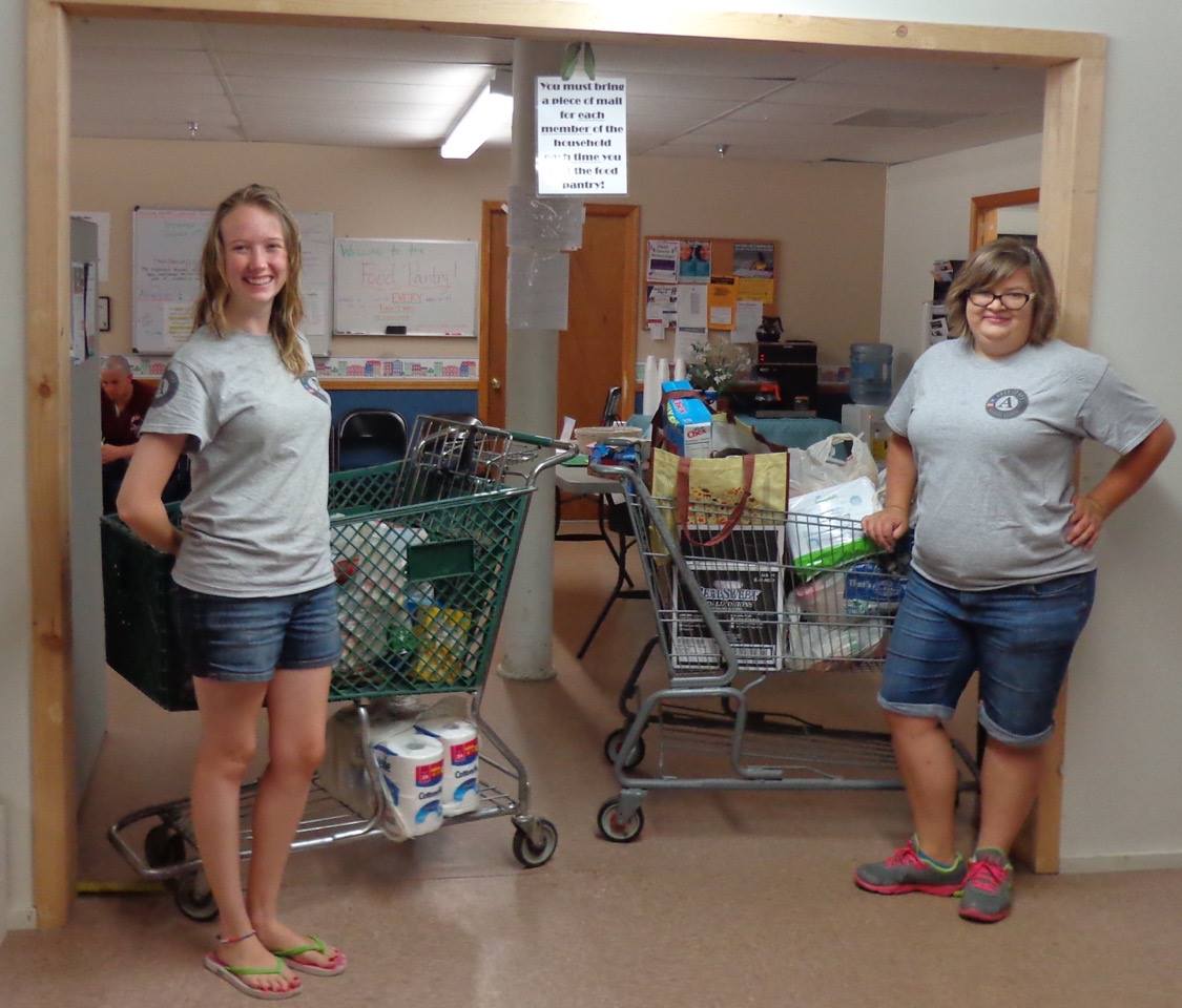 Two women standing next to each other in a room with shopping carts