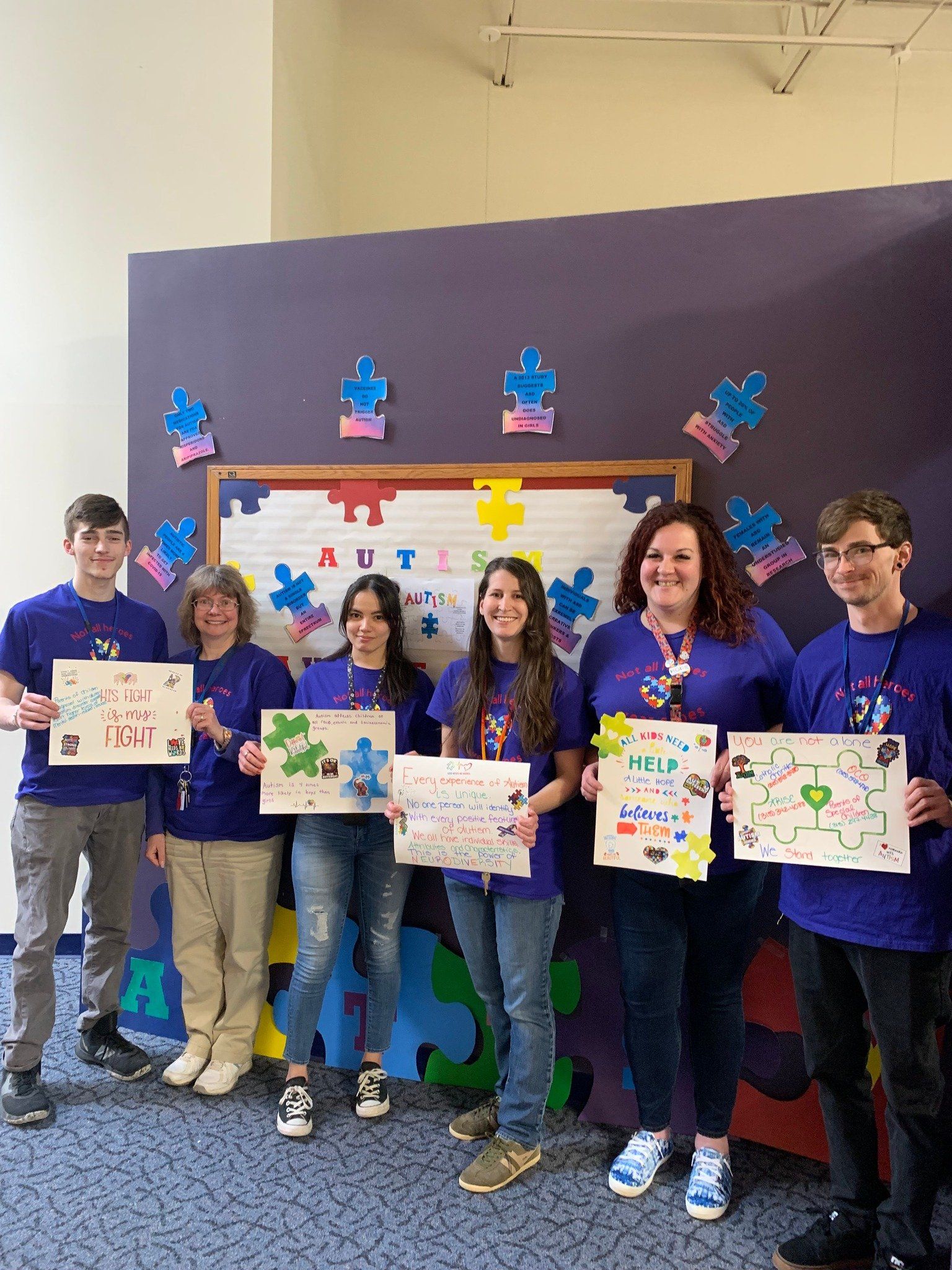 A group of people standing next to each other holding signs.