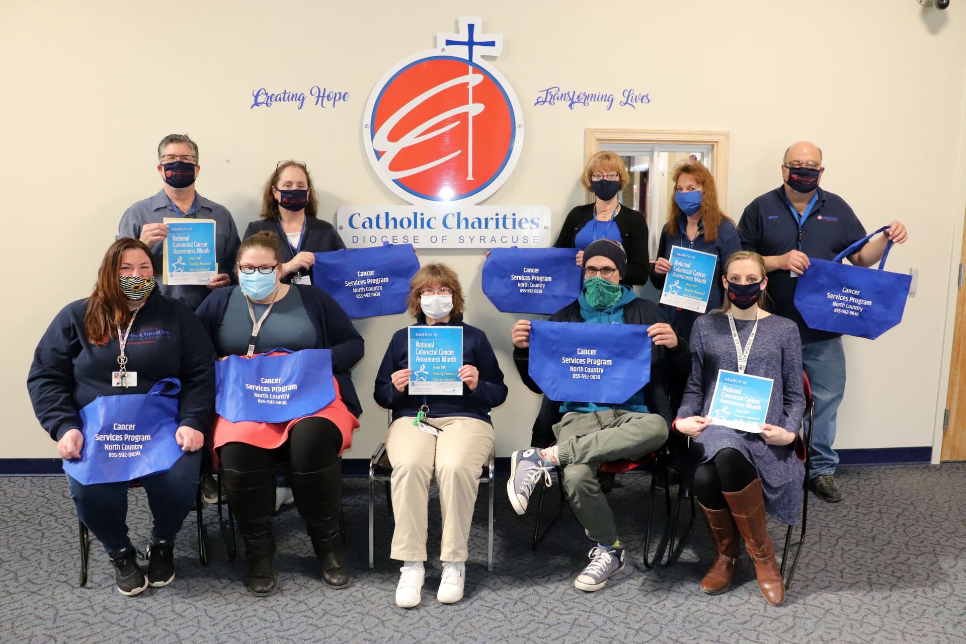 A group of people wearing face masks are posing for a picture.
