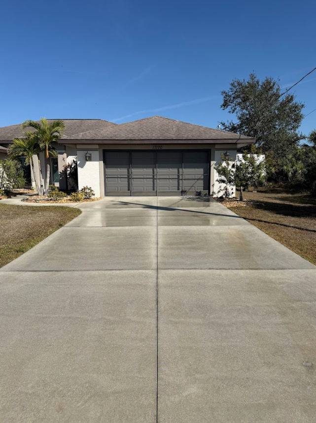 Stone paver walkway curves through a grassy yard and garden bed.