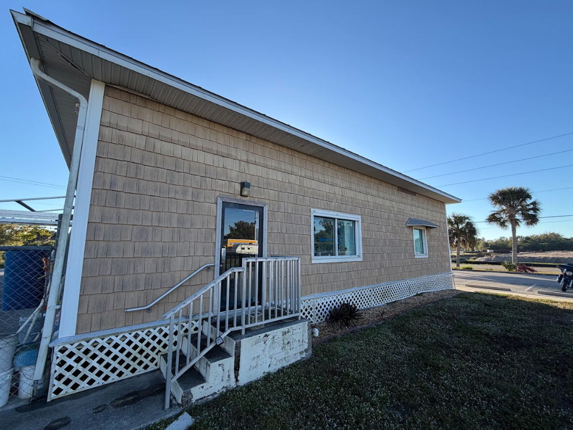 Stone paver walkway curves through a grassy yard and garden bed.