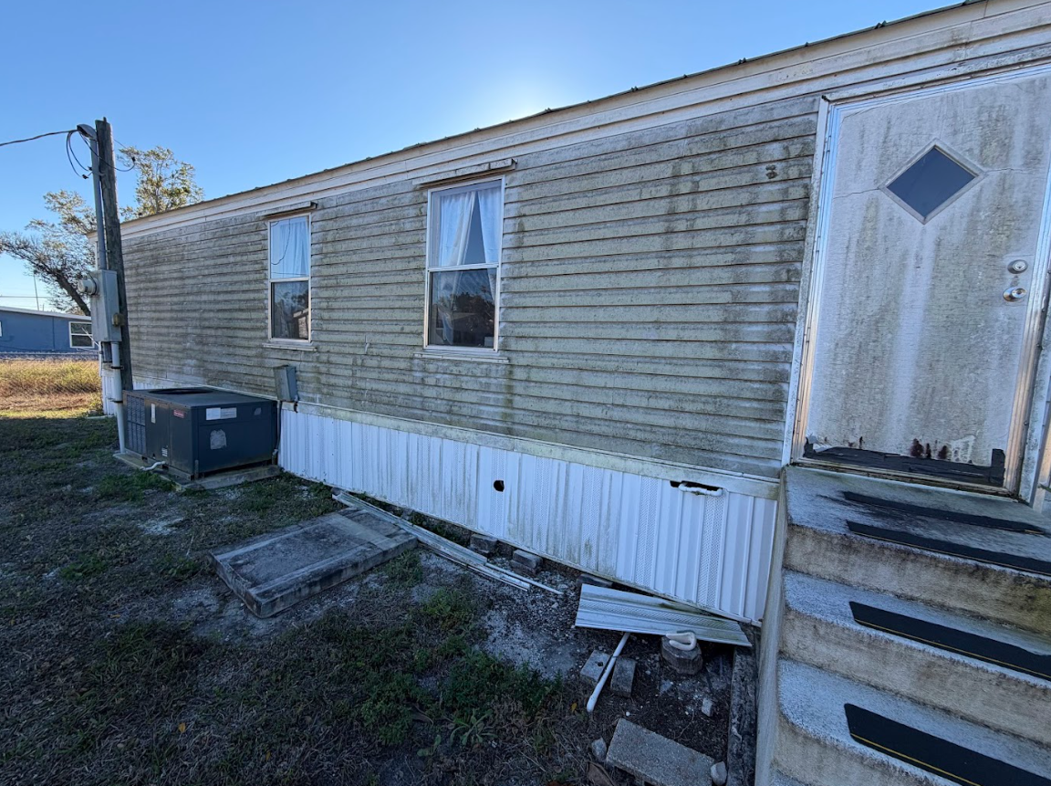 Stone paver walkway curves through a grassy yard and garden bed.