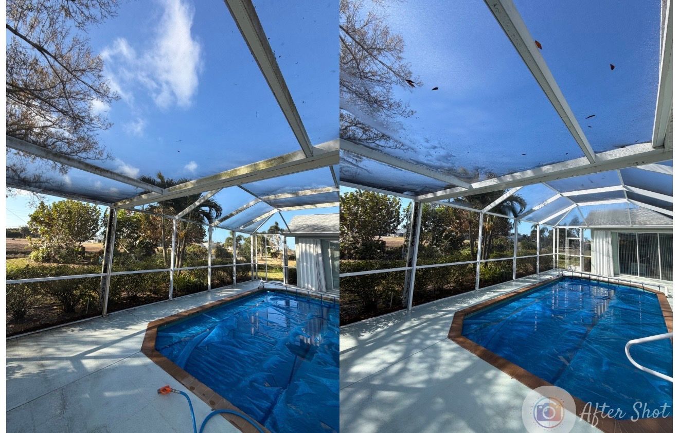Driveway paved with textured stones, flanked by green grass and a silver SUV parked in front of a house. Palm tree shadow.