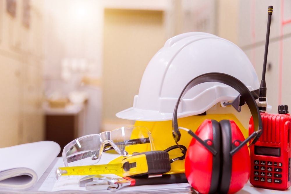 Construction Safety Gear: White and Yellow Hard Hats, Safety Glasses, Ear Muffs, Measuring Tape, and A — Tomac Civil In Burleigh Heads, QLD Red Walkie-Talkie