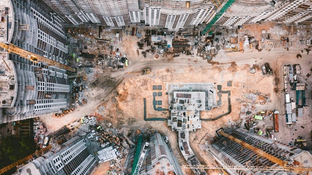 An Aerial View of a Construction Site With Lots of Buildings and Cranes — Tomac Civil in Burleigh Heads, QLD