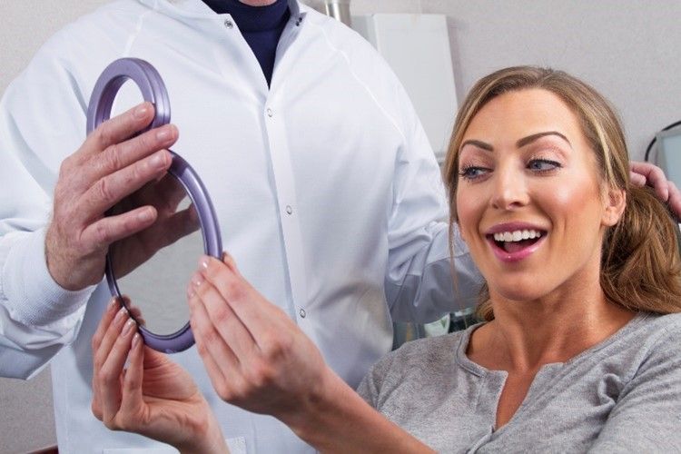A woman is smiling while looking at herself in a mirror.