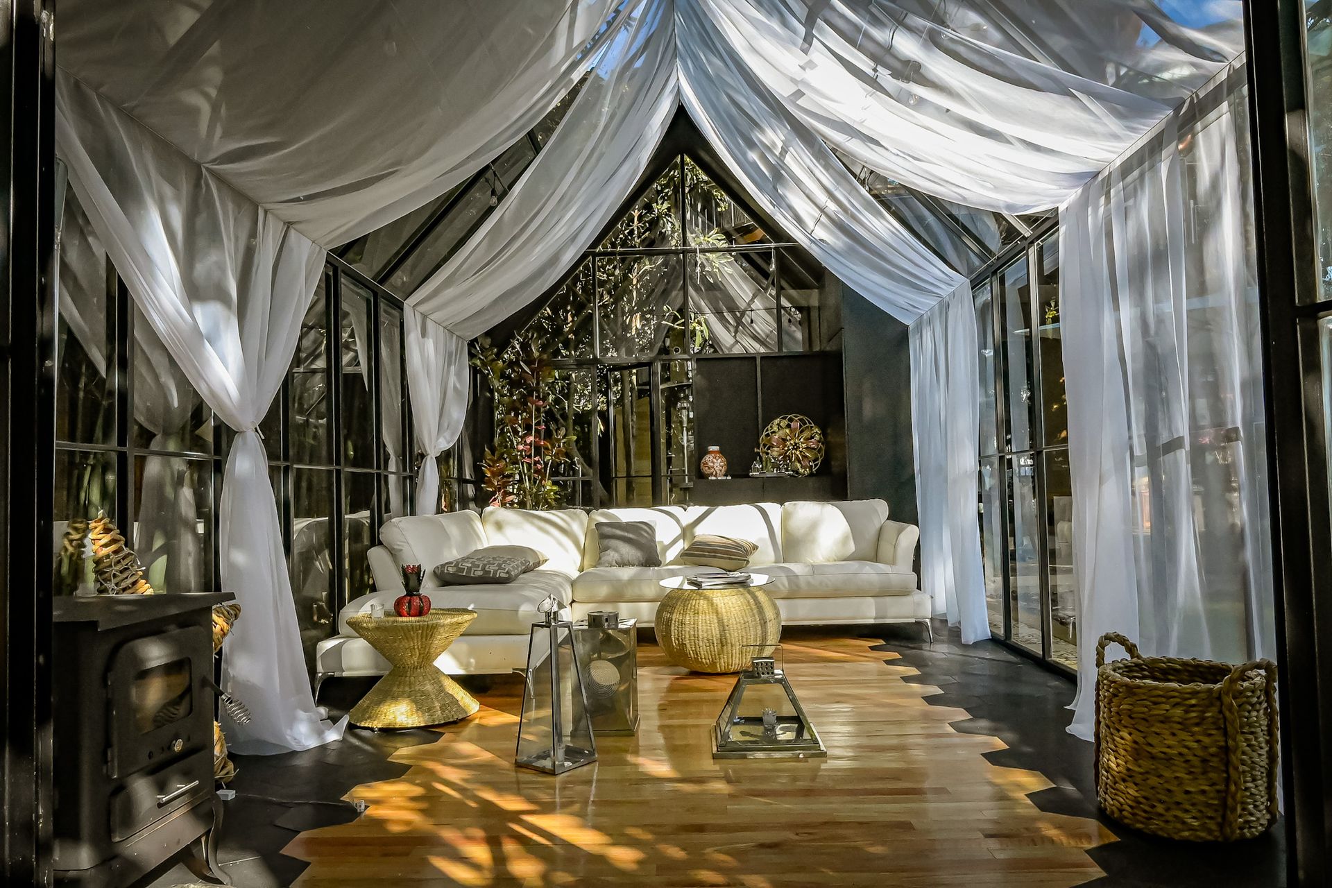 Una sala de estar con sofá, mesa y cortinas.