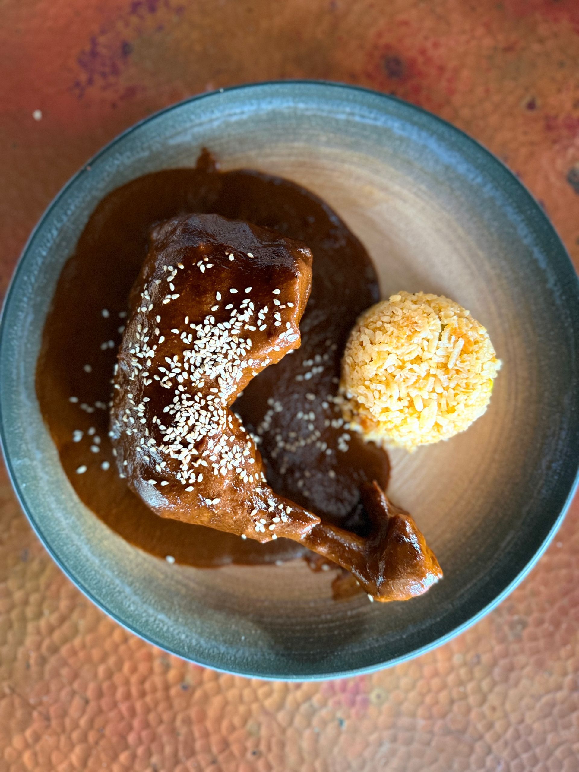 Un plato de comida con carne y arroz en una mesa.