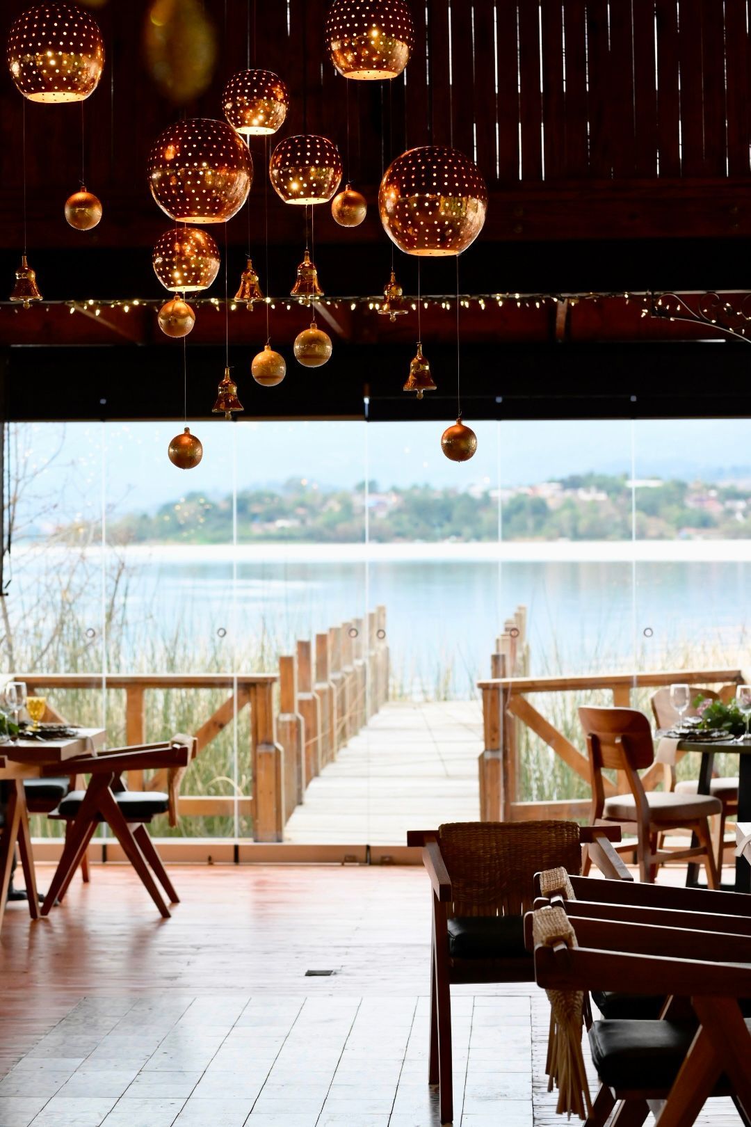 Un restaurante con mesas y sillas y vista a un lago.