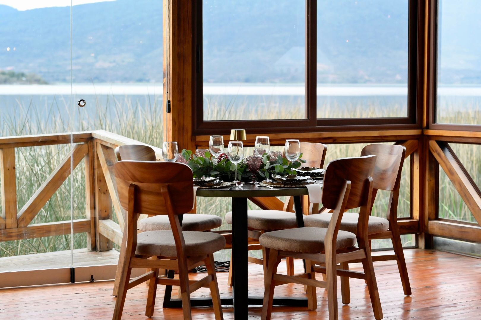 Una mesa y sillas en una habitación con vista a un lago.