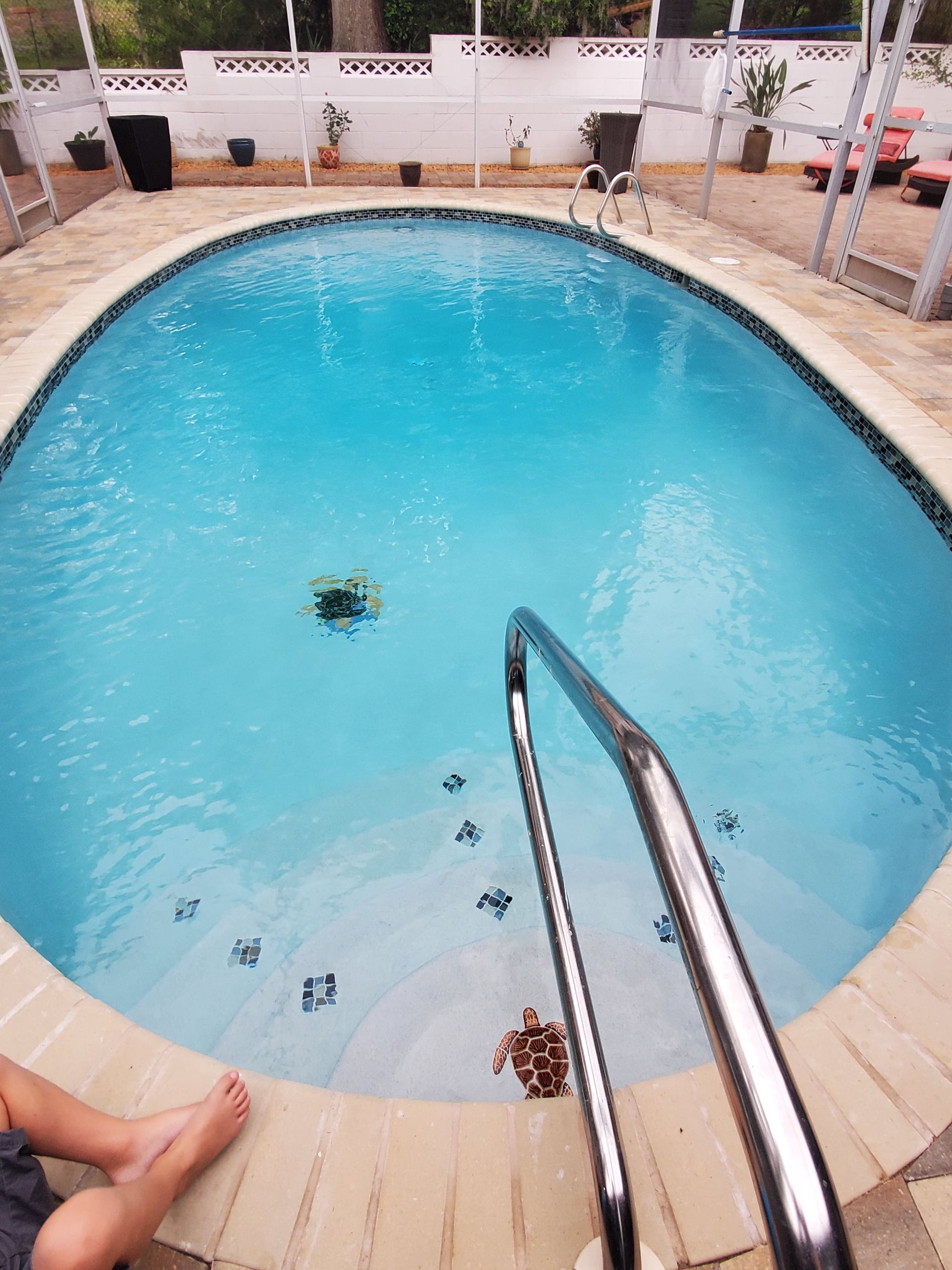 A child is sitting on the edge of a swimming pool.