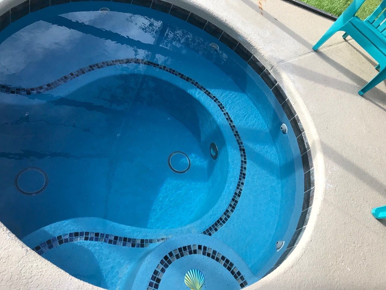 A blue hot tub with a blue chair in the background
