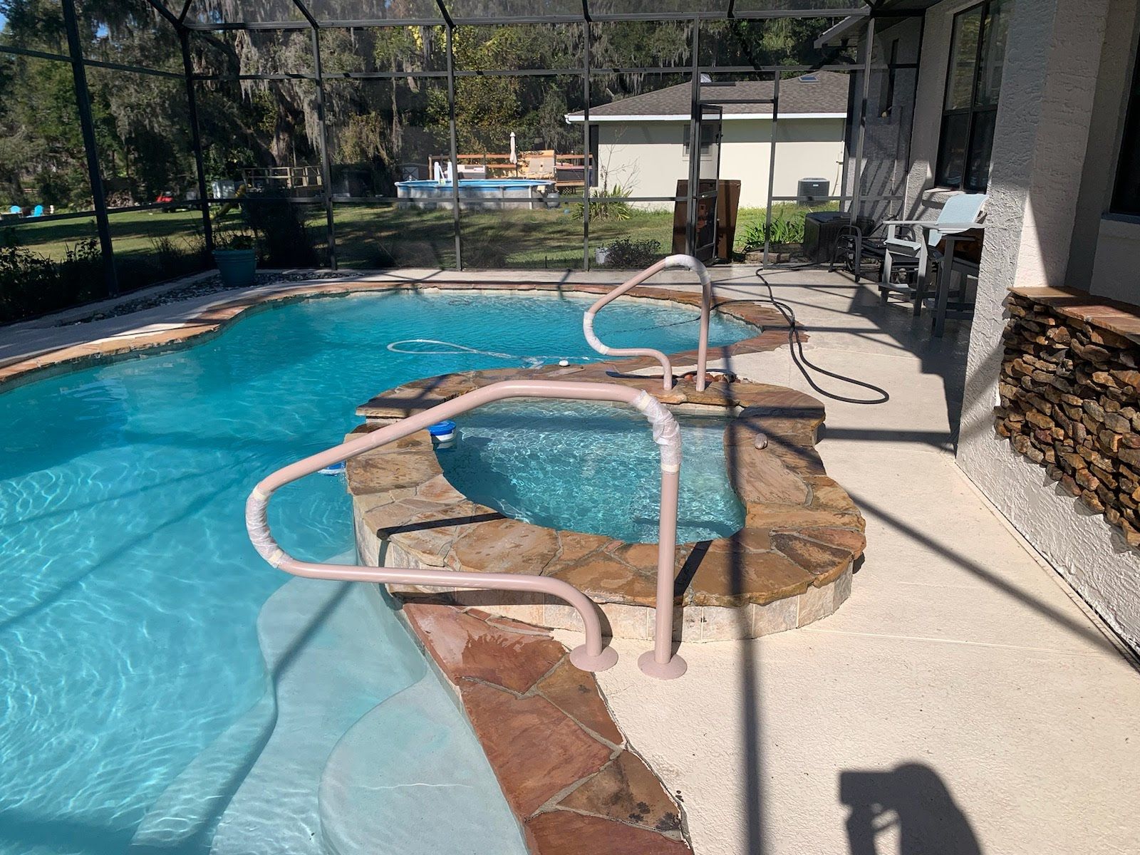 A large swimming pool with a hot tub in the middle of it.