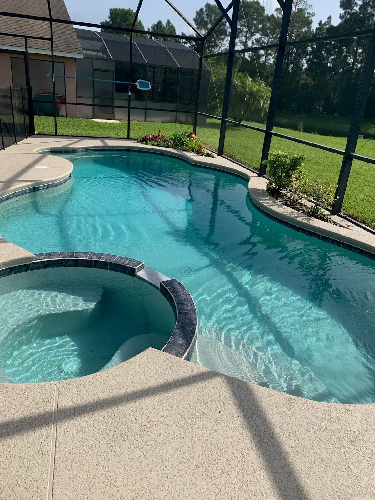 A large swimming pool with a hot tub in the middle of it.