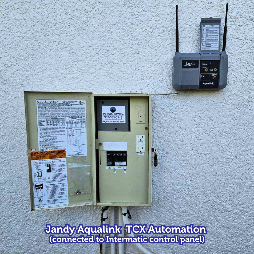 Jandy Aqualink TCX automation panel on a light-colored wall, connected to an Intermatic control panel.