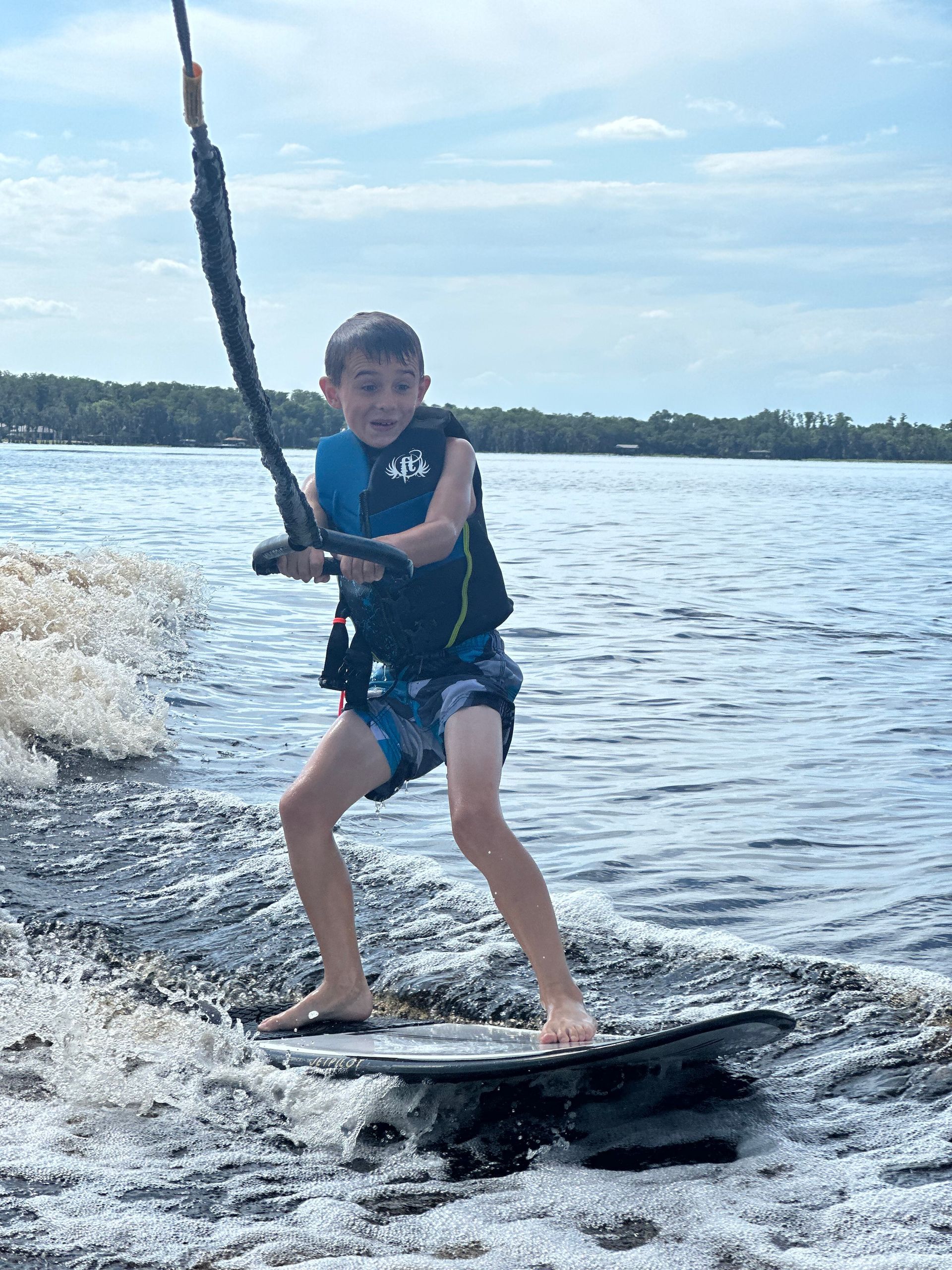 A young boy is riding a wakeboard in the water.