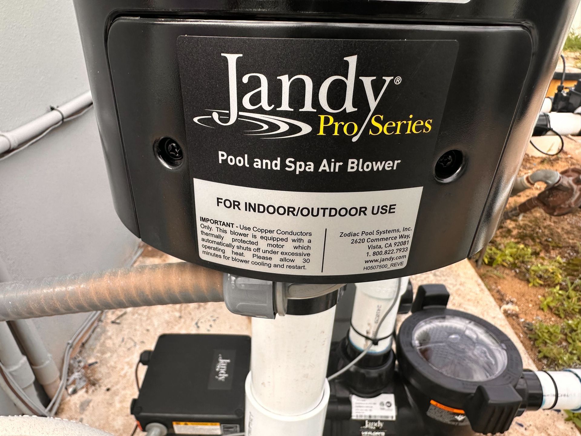 Jandy Pro Series pool air blower, black housing, white PVC pipe, black control box, and pool pump.