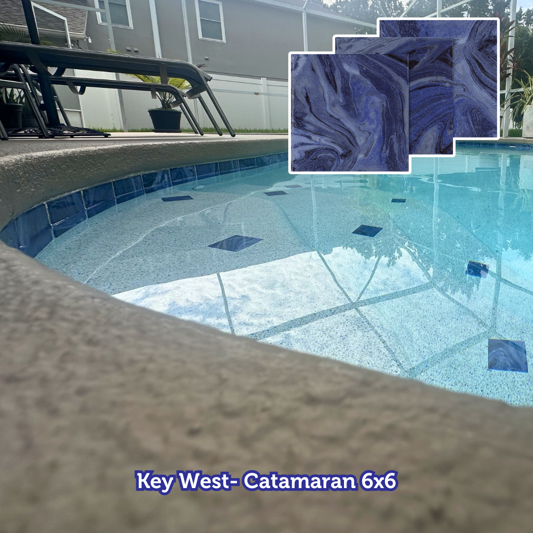 Pool with blue and gray tiles, surrounded by a gray deck. Sample tiles in the corner.