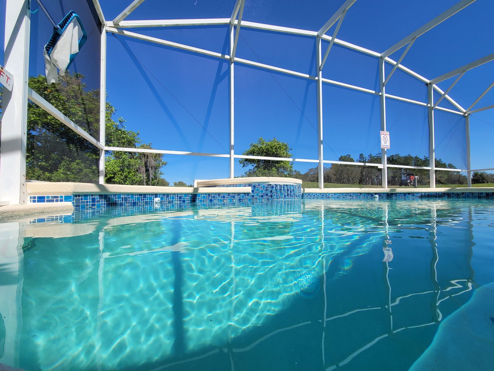 A swimming pool with a fence around it and a blue sky in the background.