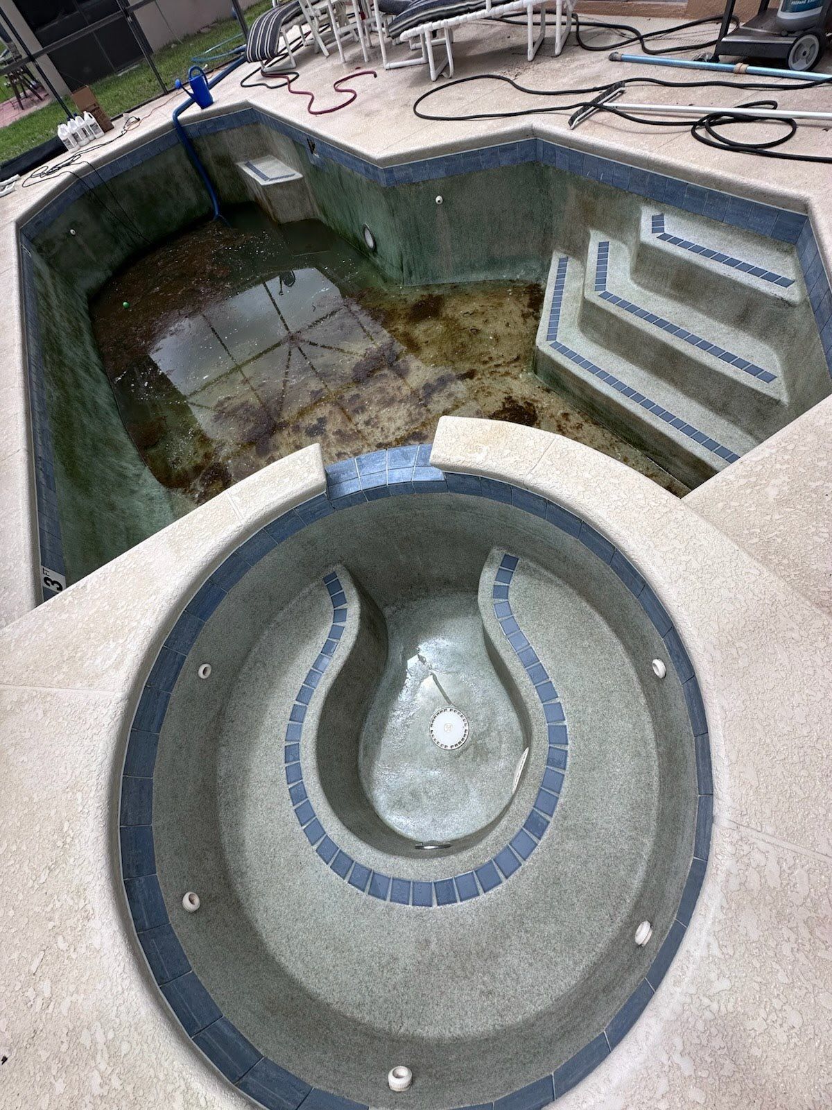 A swimming pool with a hot tub in the middle of it.