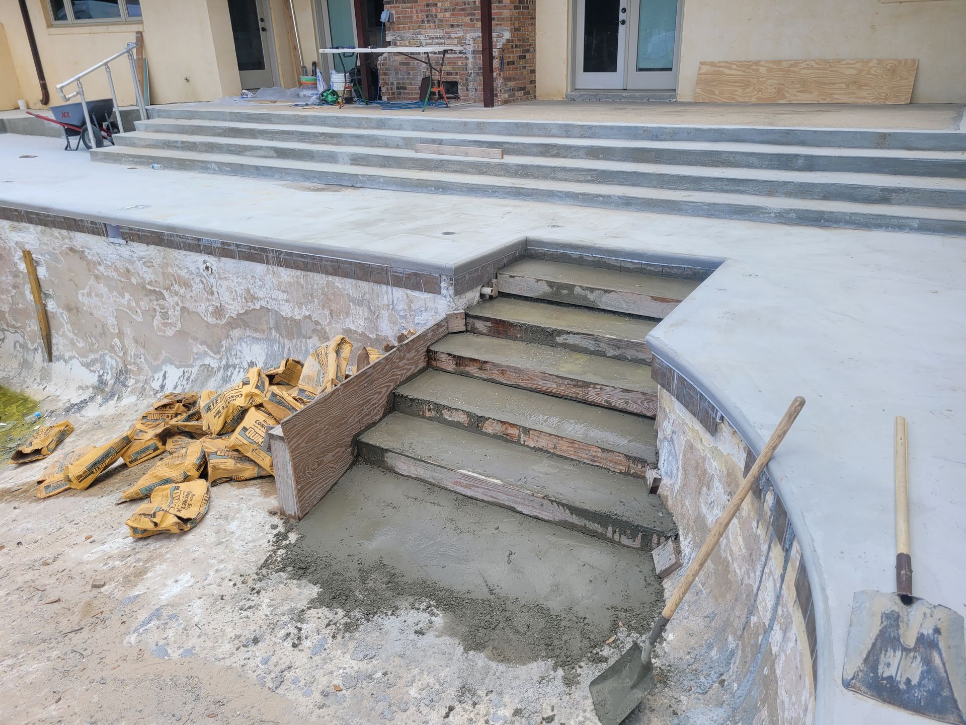 A concrete staircase is being built into a pool.