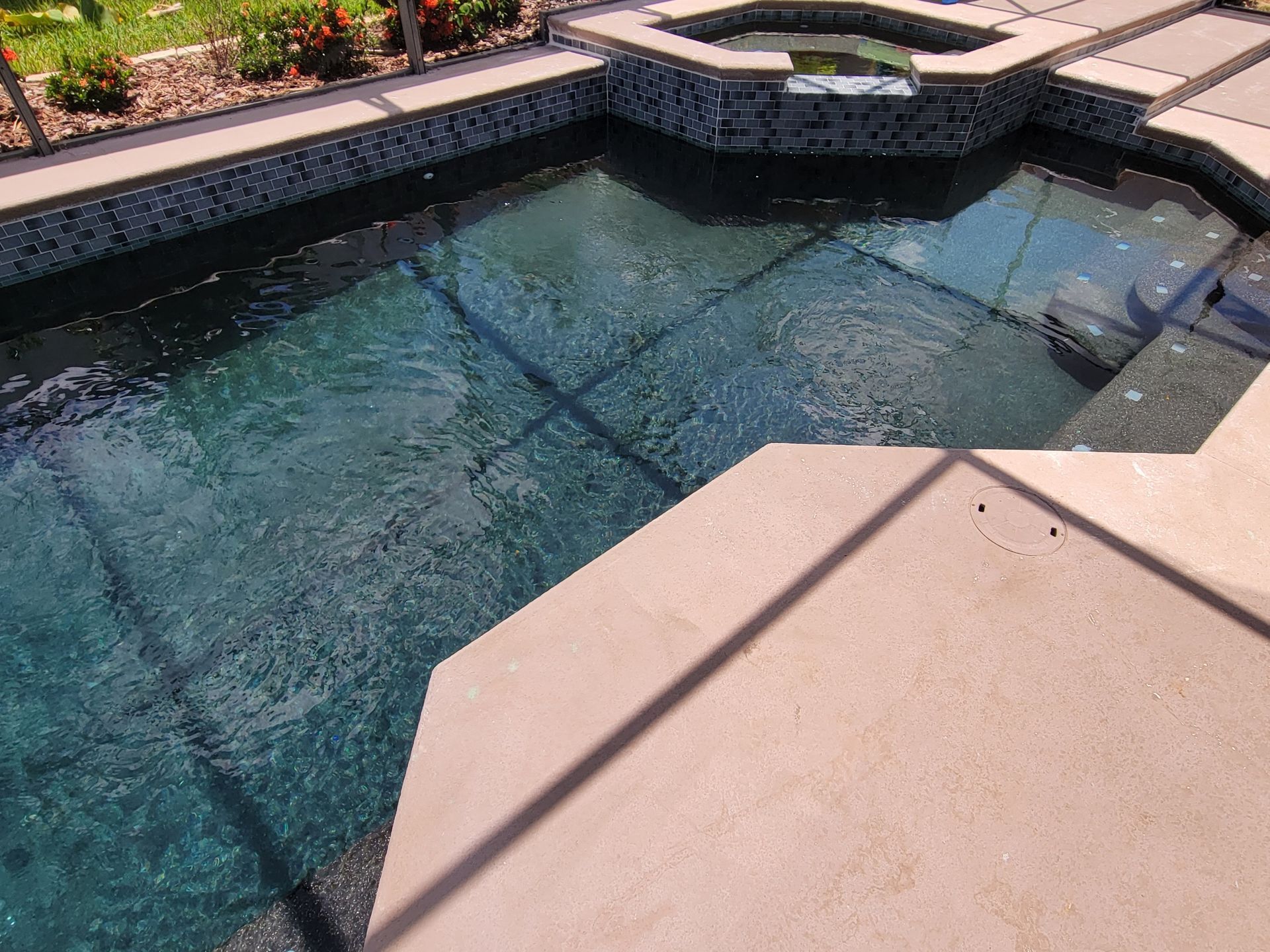 A large swimming pool with a hot tub in the middle