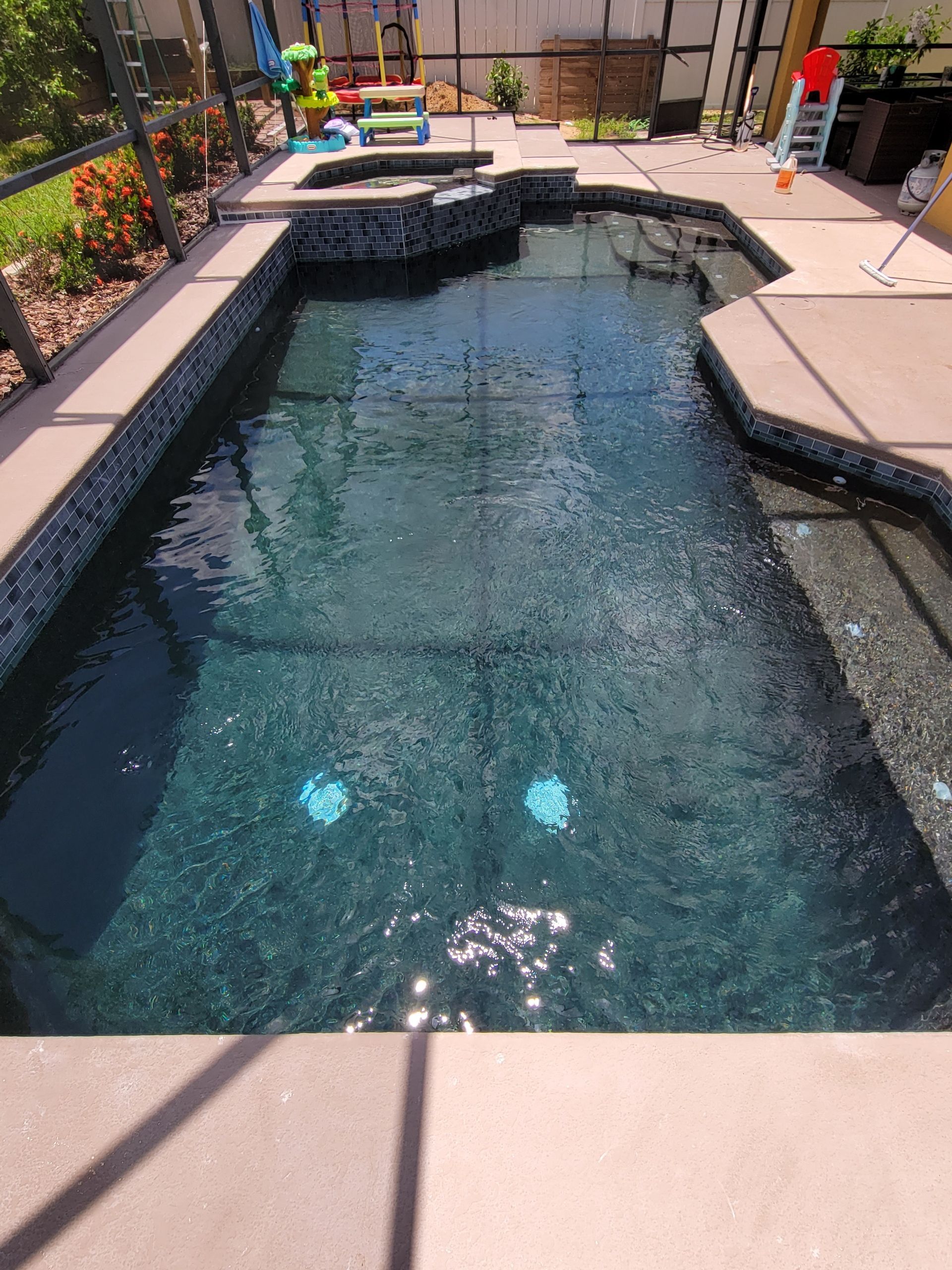 A large swimming pool is sitting on top of a concrete patio.