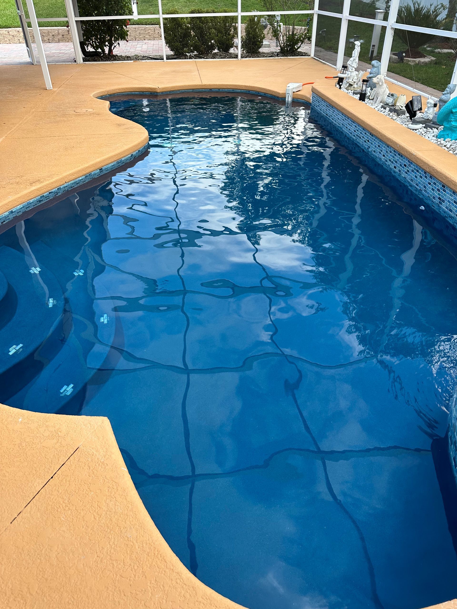 A large blue swimming pool with stairs leading to it.