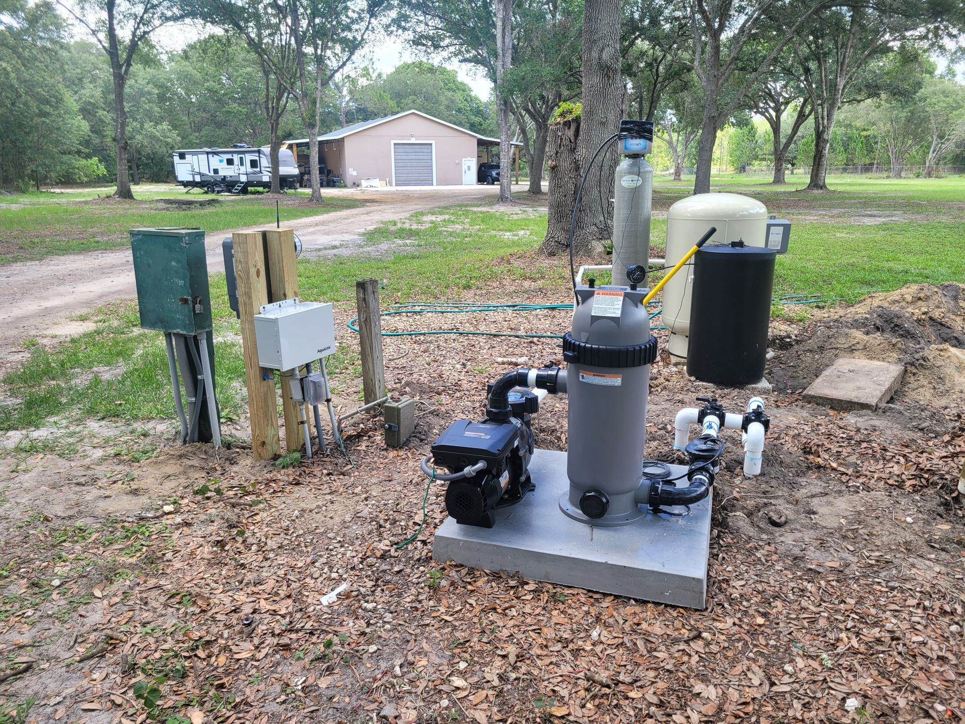 A swimming pool filter is sitting on the ground next to a house.