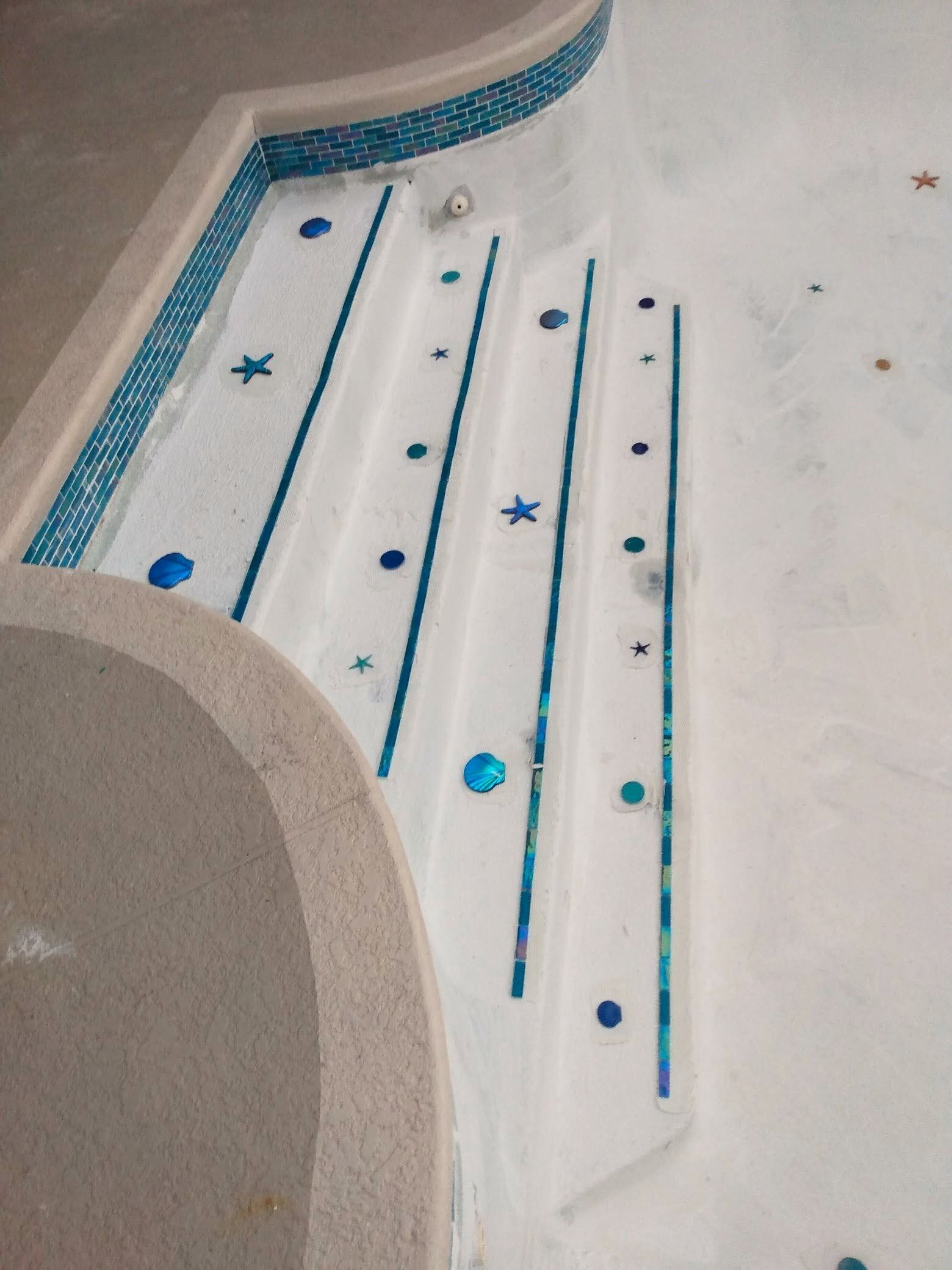 A swimming pool with blue tiles and white steps