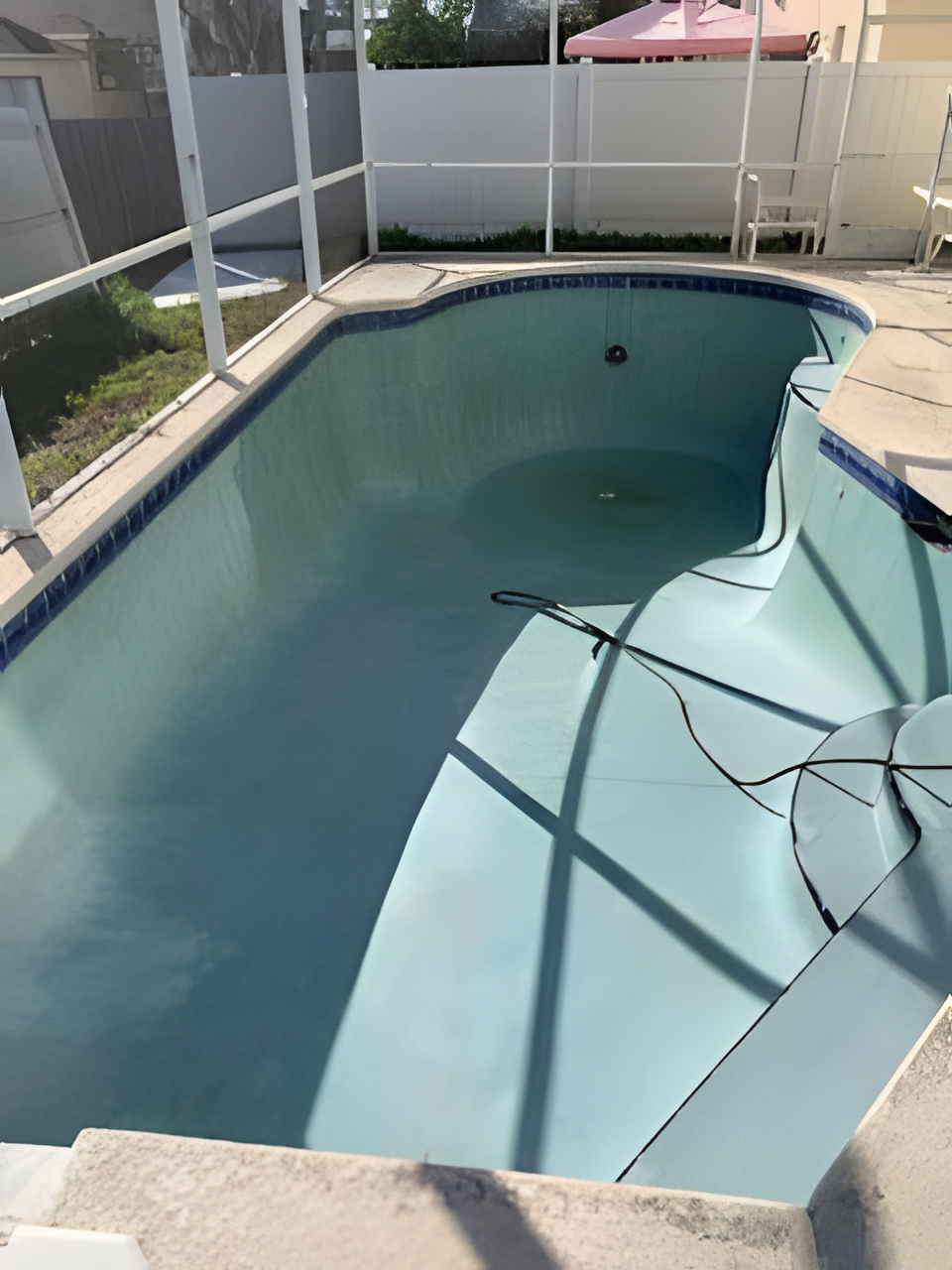 An empty swimming pool with a fence around it