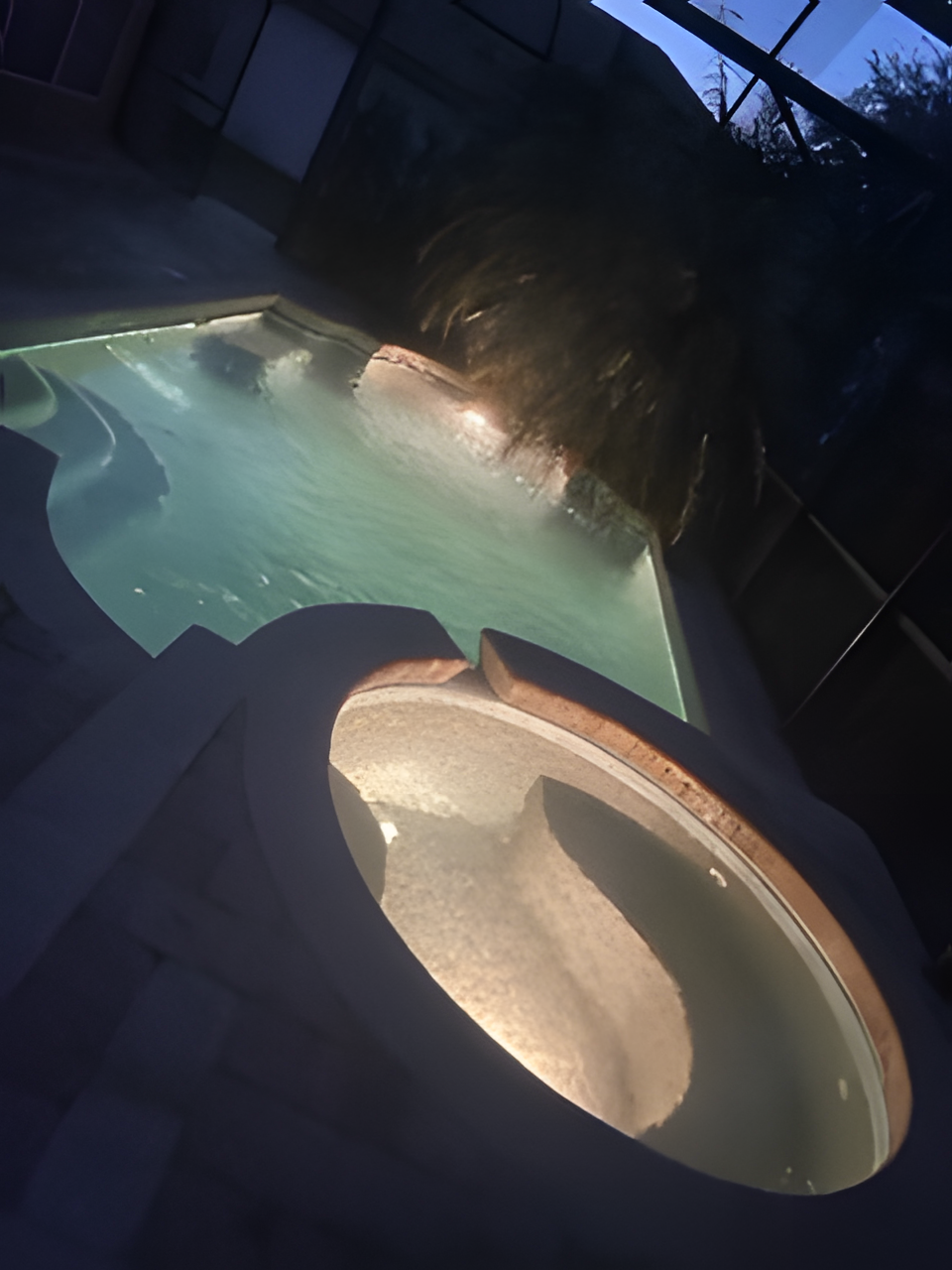 A large swimming pool is lit up at night