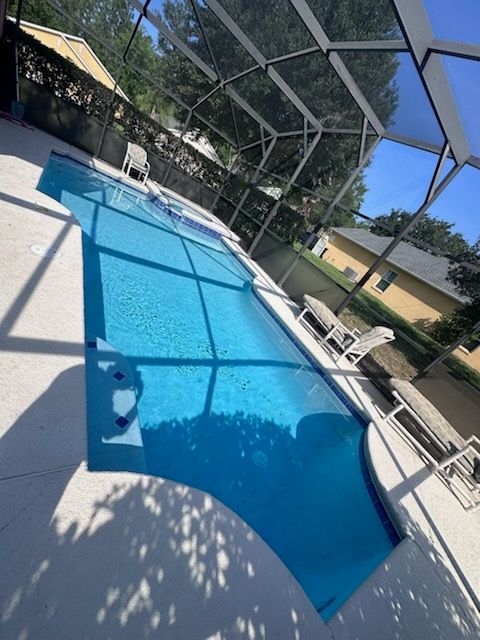 A large swimming pool surrounded by chairs and umbrellas