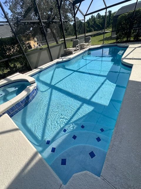 A large swimming pool surrounded by a screened in area