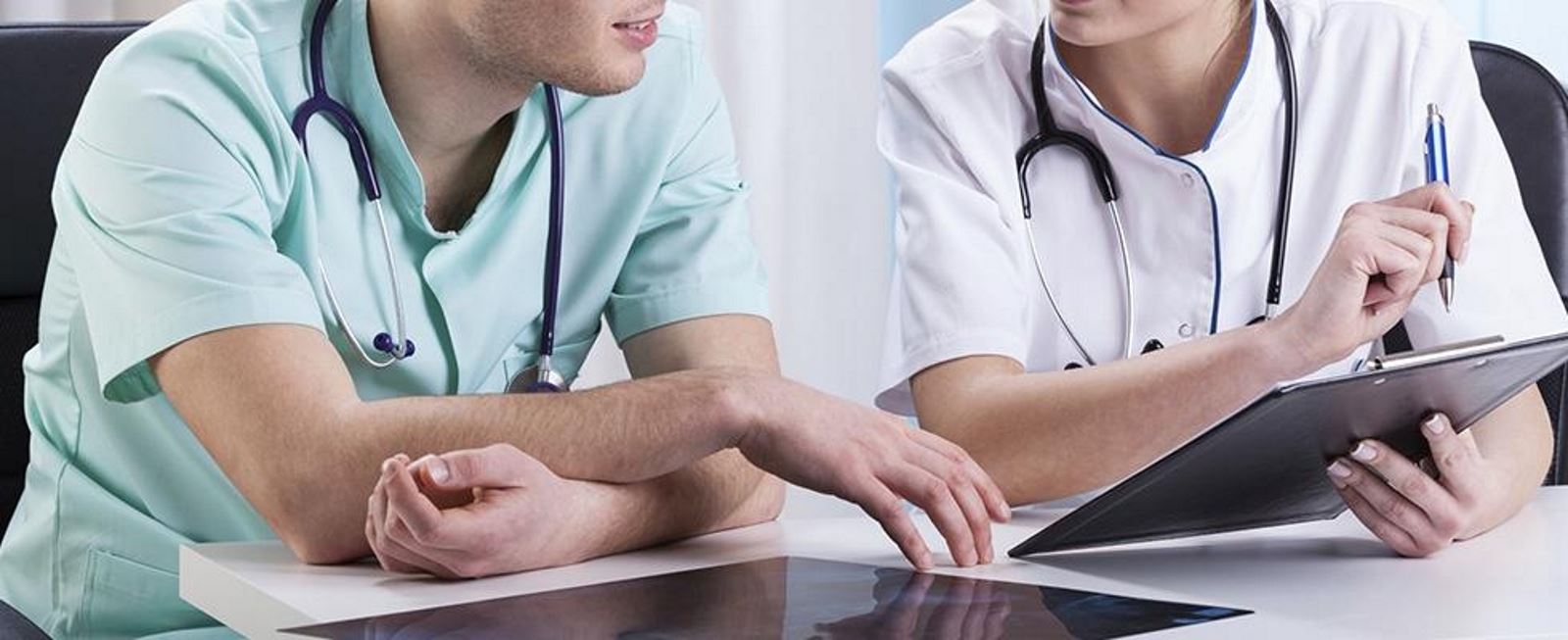 due medici di cui cuno con una penna e una cartella in mano