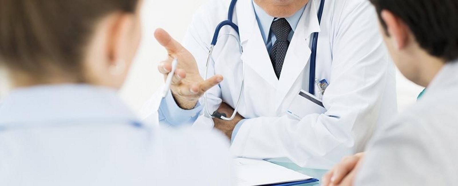 tre medici mentre parlano seduti al tavolo