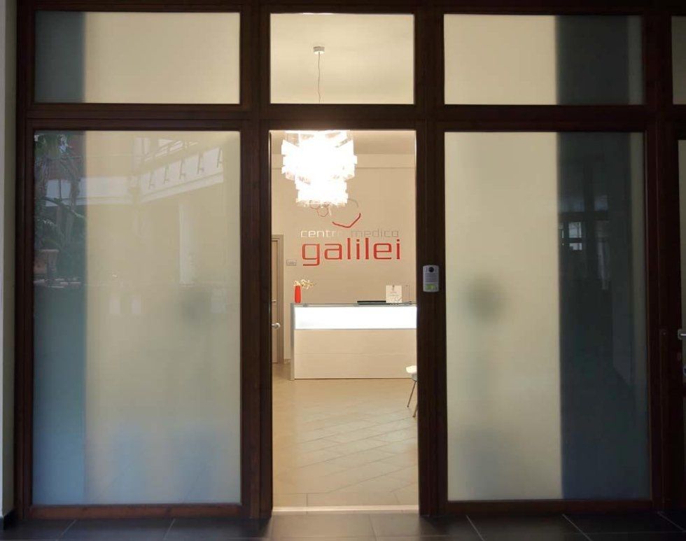 una reception e la scritta sul muro centro medico Galilei vista da una porta socchiusa