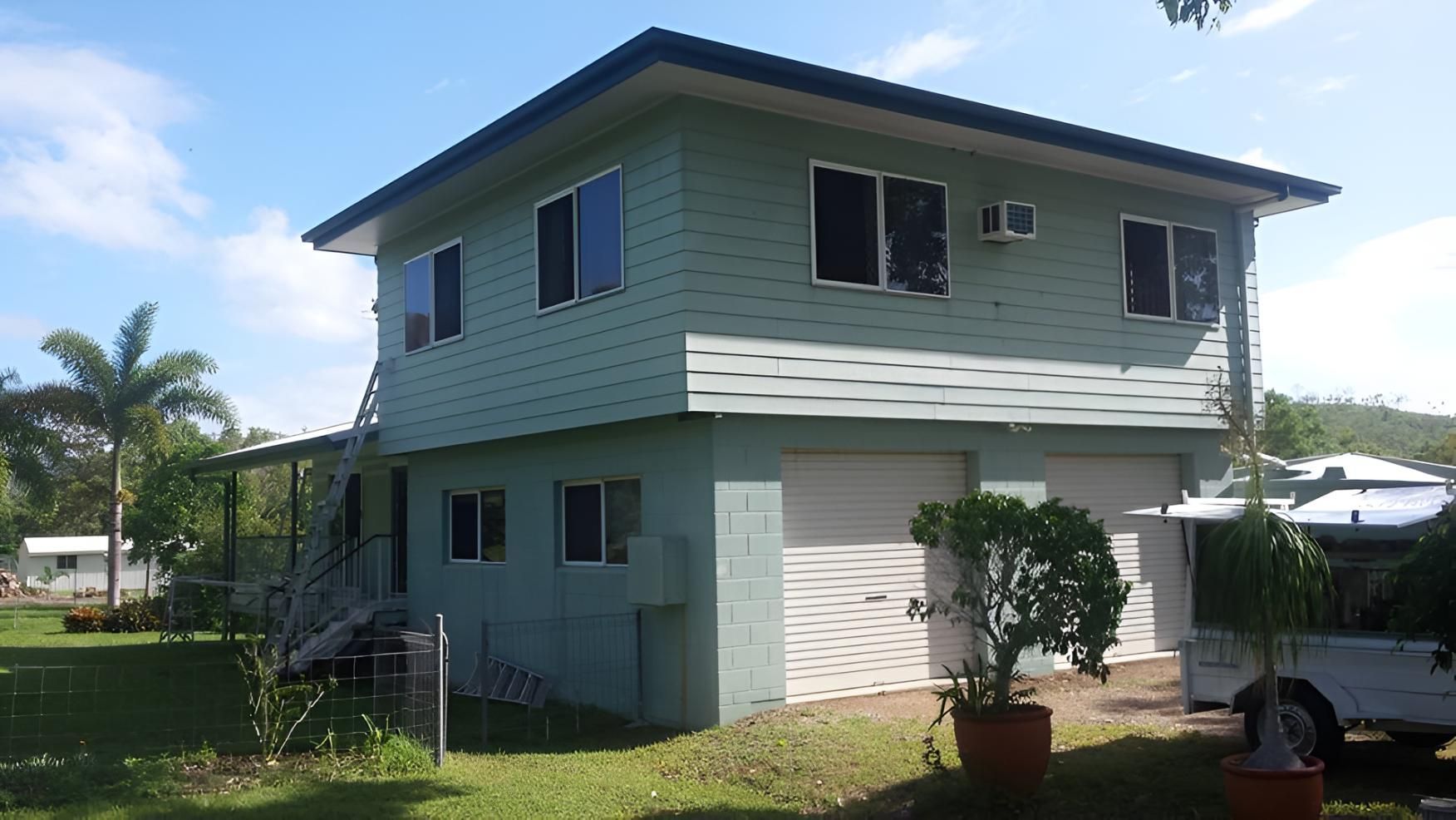 A Green House With A White Truck Parked In Front Of It — Aaron Lee Painting Pty Ltd In Townsville City, QLD