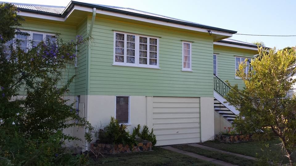 A Green And White House With A Garage And Stairs — Aaron Lee Painting Pty Ltd In Jensen, QLD