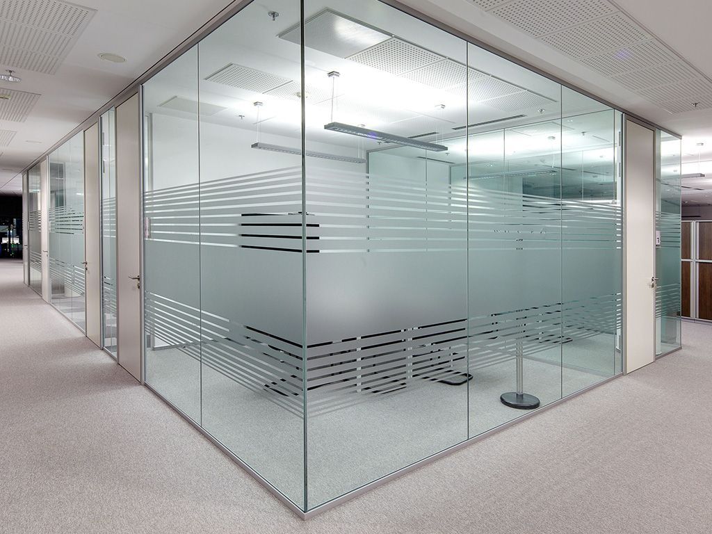Modern office space with glass walls and frosted horizontal stripes.