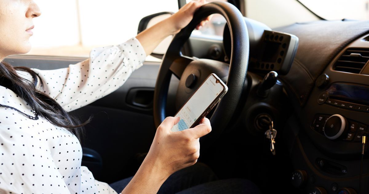 woman driving a car while texting