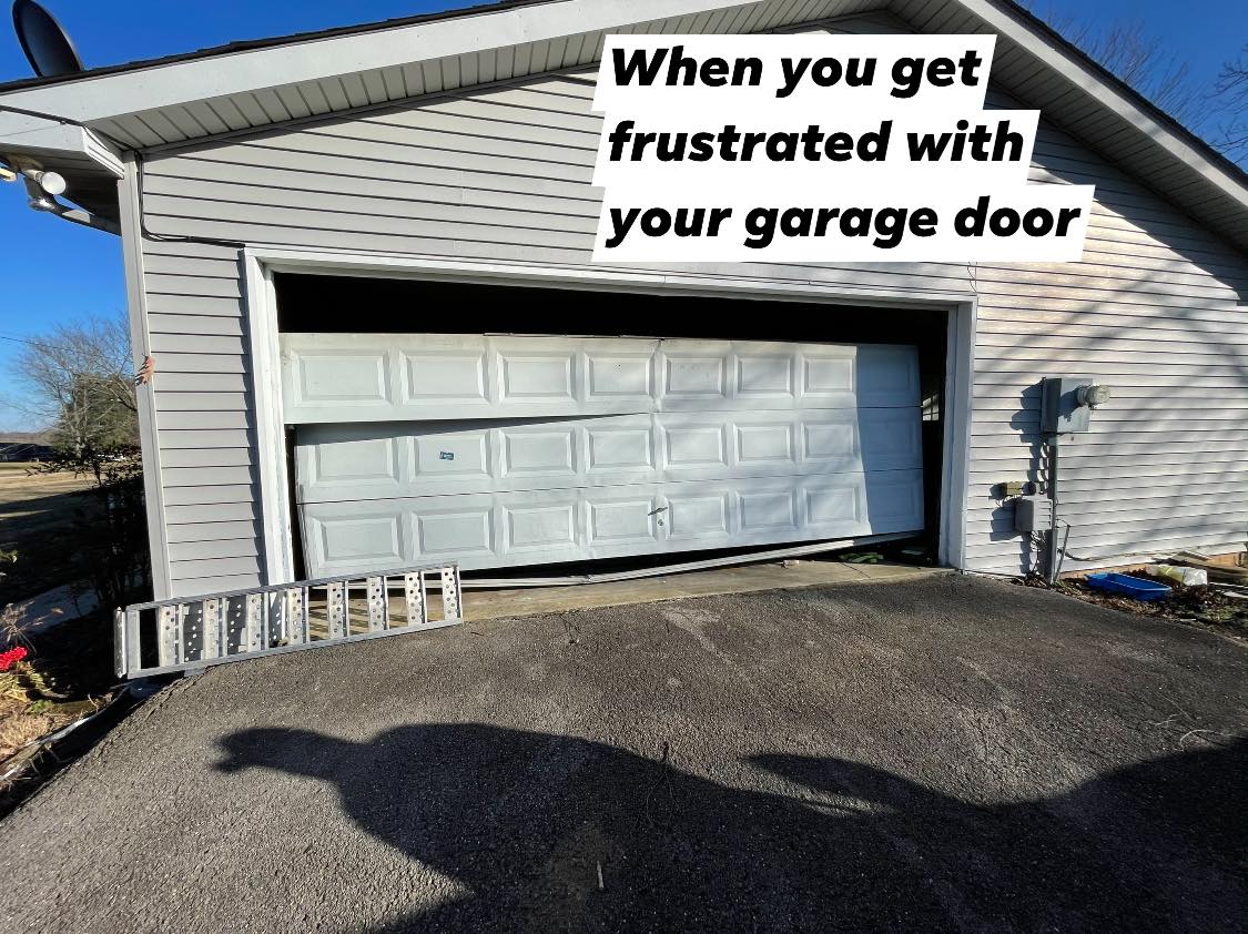 A bent, white garage door in an open garage. The image has a caption 