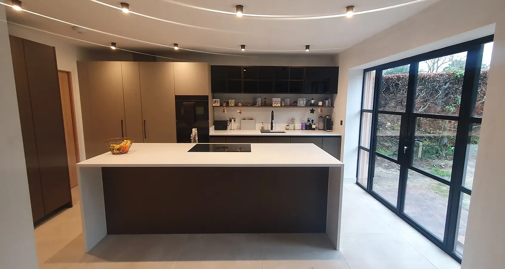 A kitchen with a large island and sliding glass doors.