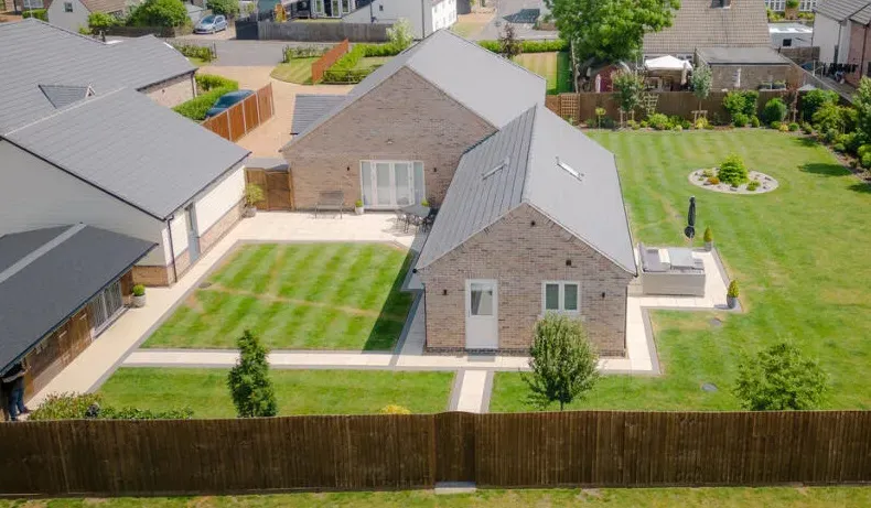 An aerial view of a residential area with houses and a large lawn.