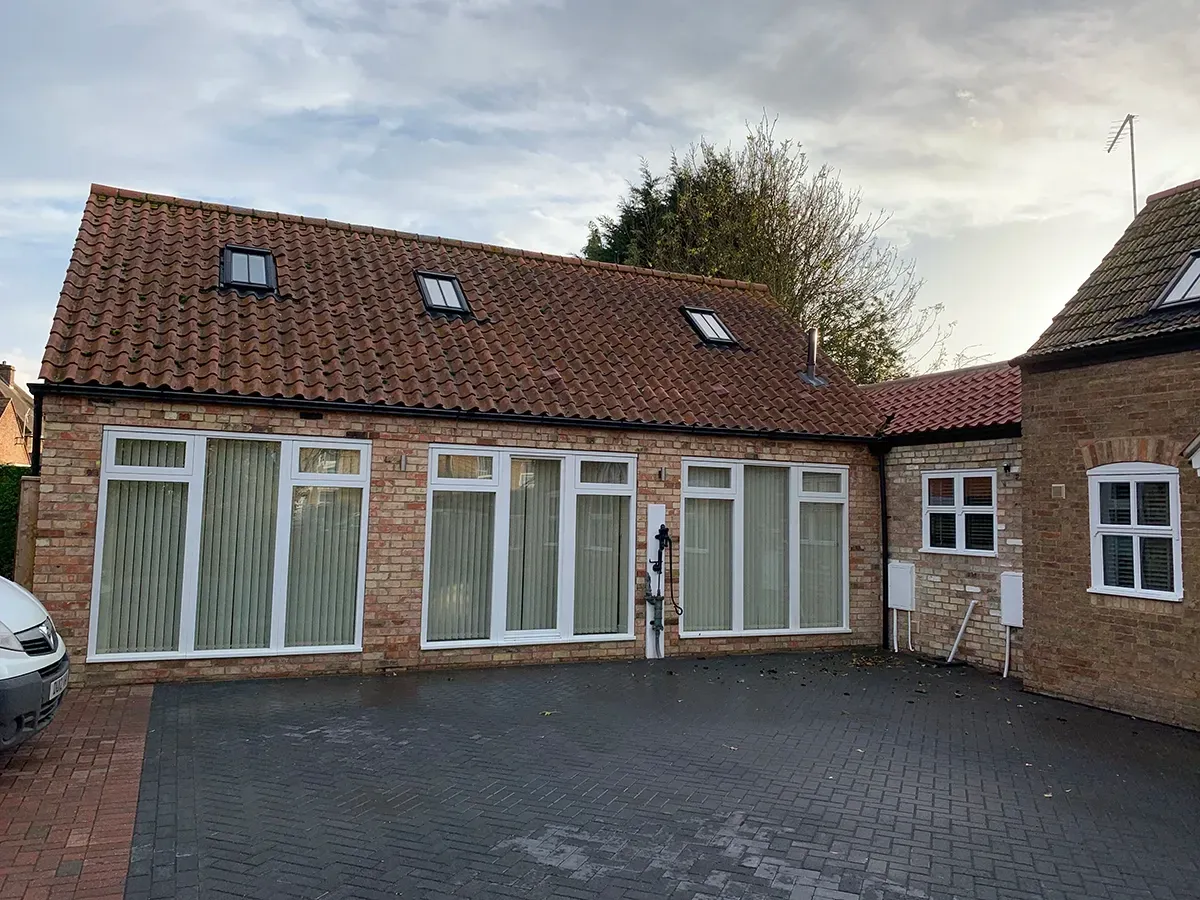 A brick building with a white van parked in front of it.
