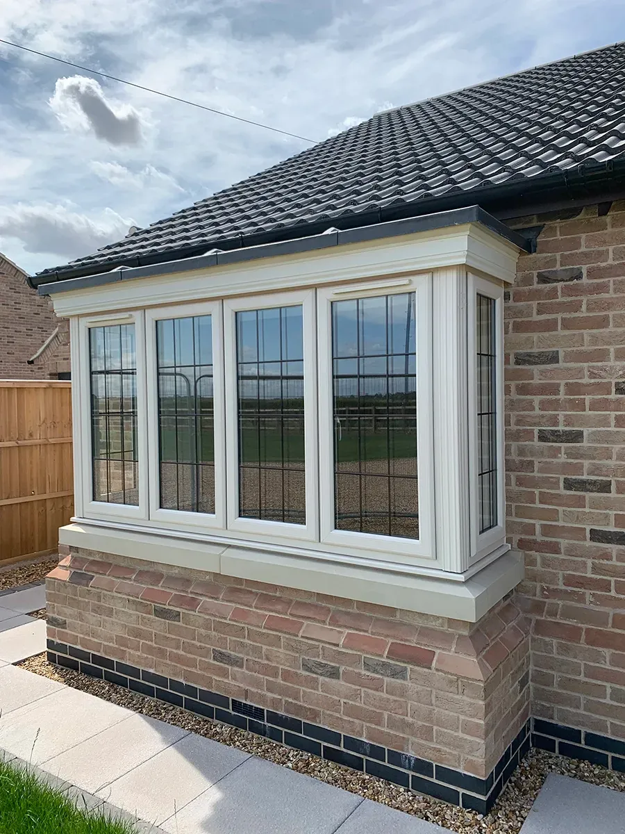 A brick house with a large window on the side of it.